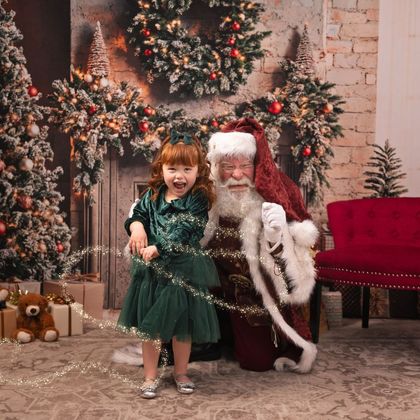Little girl with Santa in a holiday set